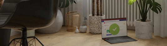 Laptop with privacy clip on floor with plants